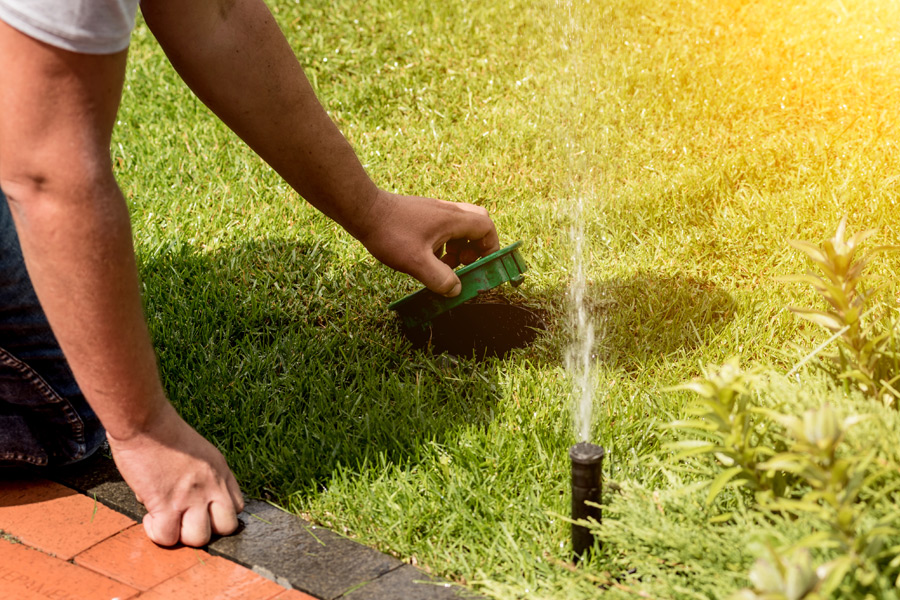 man kneeling to lift drainage cap